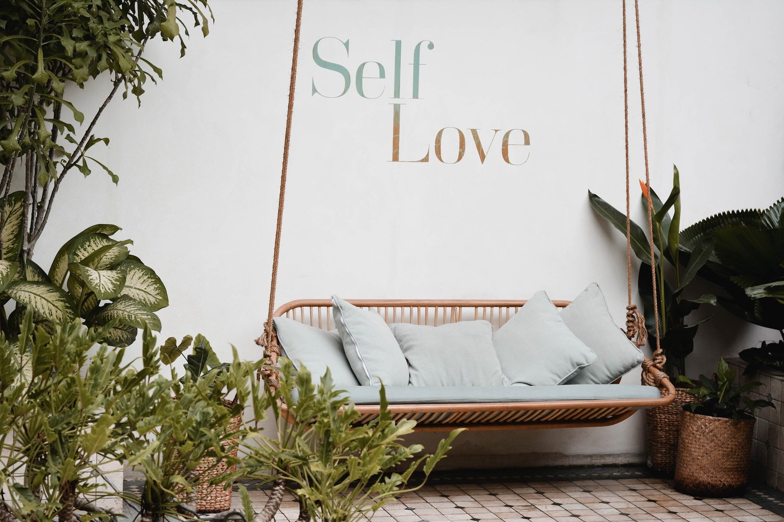 the words elf love on the wall of a room with a swing and many plants