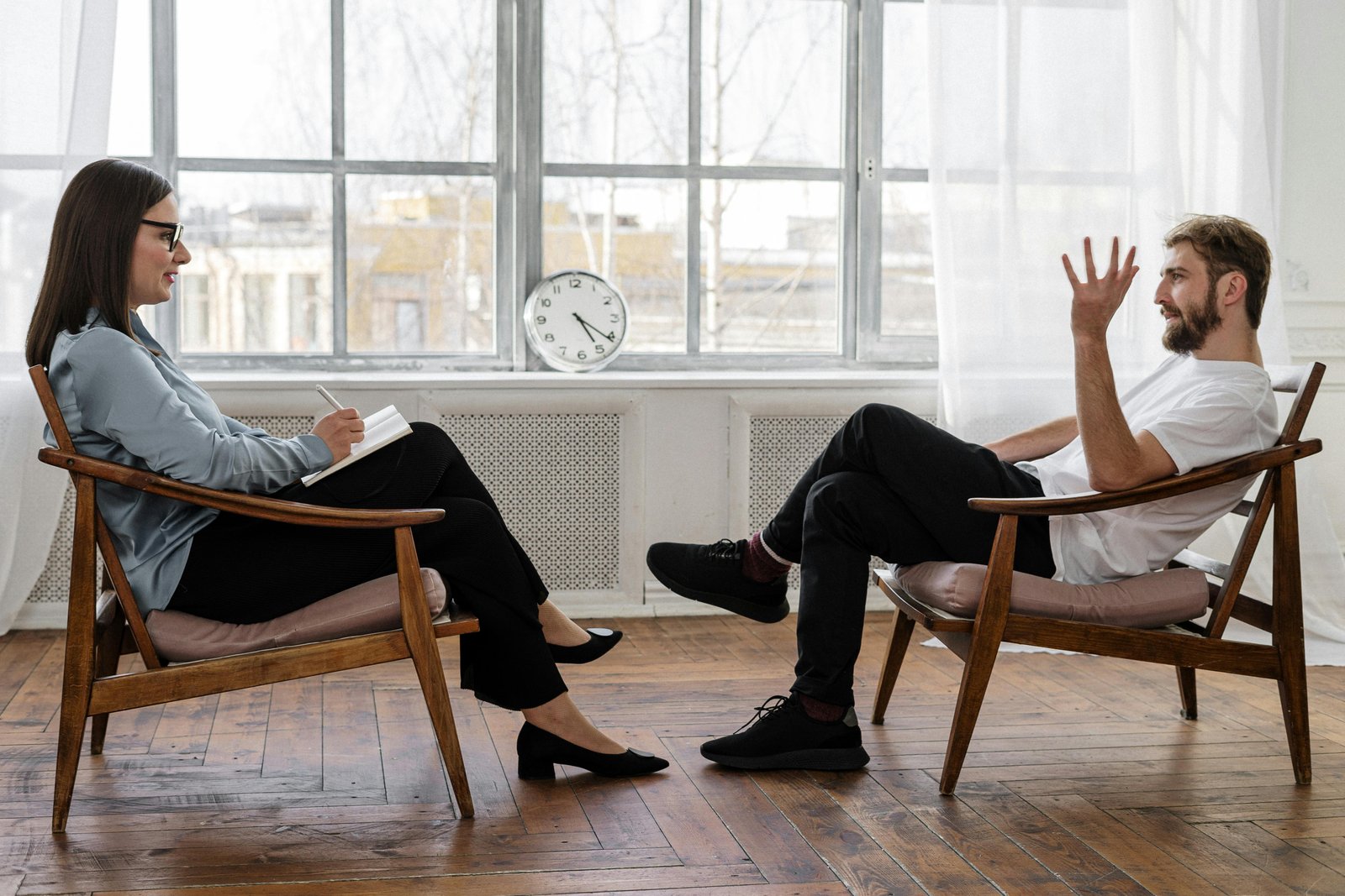 Free A therapist engaging in a counseling session with a male patient to support mental health. Stock Photo