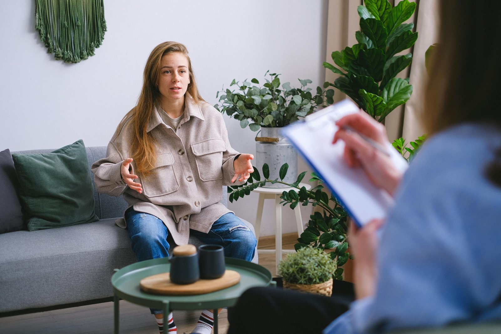 Free A woman engages in a therapy session, discussing issues with a counselor inside a modern office. Stock Photo
